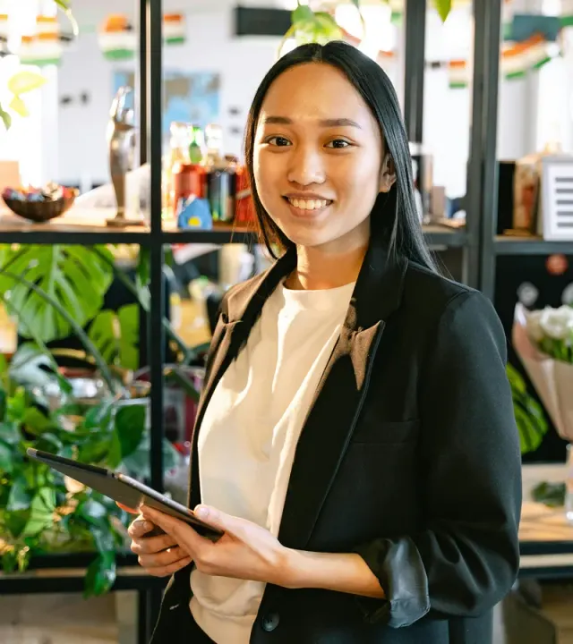 Filipina assistant holding a tablet in a professional workspace